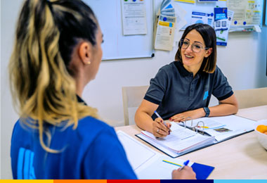 Collaboratrice ALDI Store Manager mentre svolge colloquio annuale alla collega Addetta alle Vendite