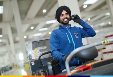 Addetto al Magazzino ALDI mentre lavora sul carrello e parla in cuffia