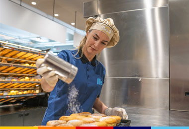 Collaboratrice ALDI Addetta alle vendite mentre si occupa del reparto panetteria