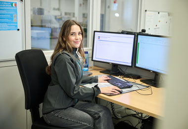 Studentessa felice di lavorare in ALDI che si occupa di inserire dati al computer