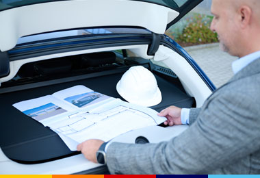 Collaboratore ALDI Sviluppo Immobiliare con caschetto mentre studia il progetto del punto vendita