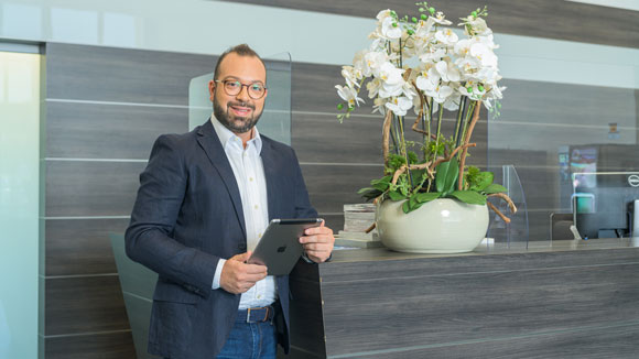 Dipendente ALDI sorridente in ufficio con fiori bianchi